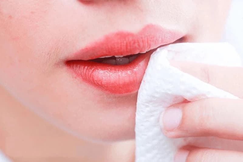 Sau khi đi ngoài về, hãy dùng bông tẩy trang thấm nước muối sinh lý để nhẹ nhàng lau sạch môi