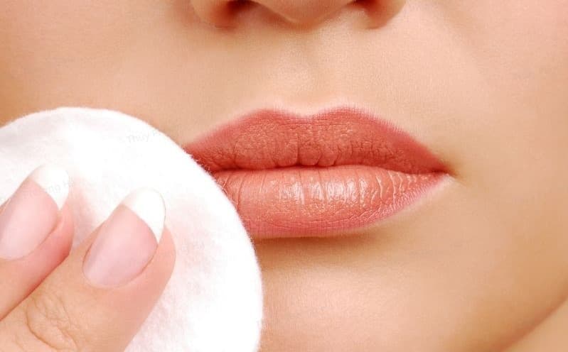 Đắp bông gòn lên môi sau khi phun xăm