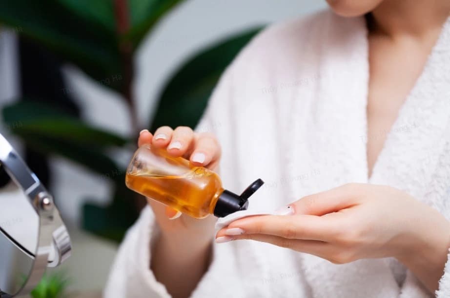 Dùng bông gòn để thoa dầu dưỡng để tránh khô môi